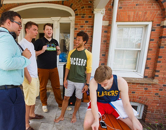 group of male students hanging out in front of a residence hall