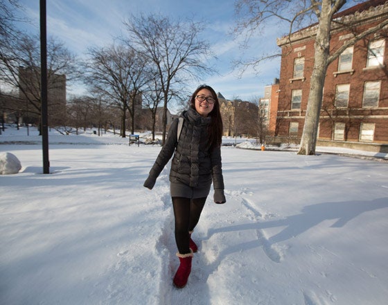Student walking by the dorms through snow