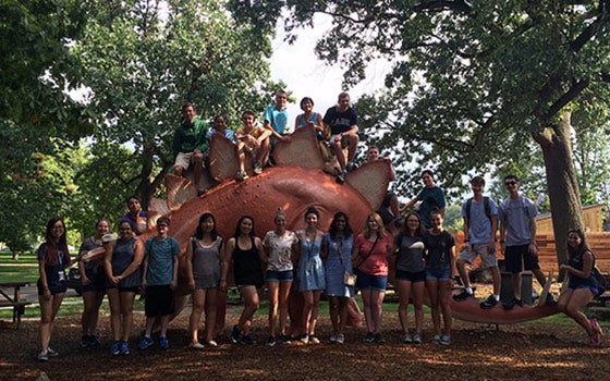 CWRU Students posing in front of a dinosaur