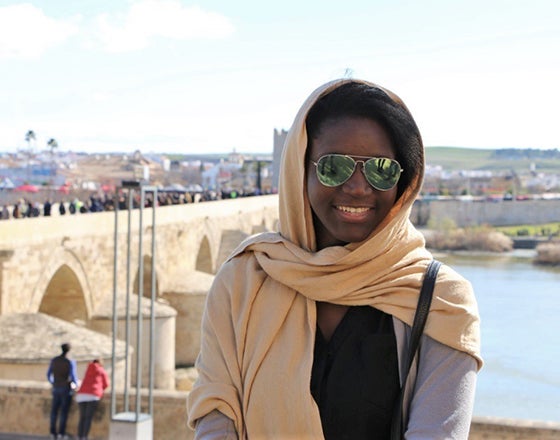 Smile Bridge Student smiles at the camera with a bridge in the background