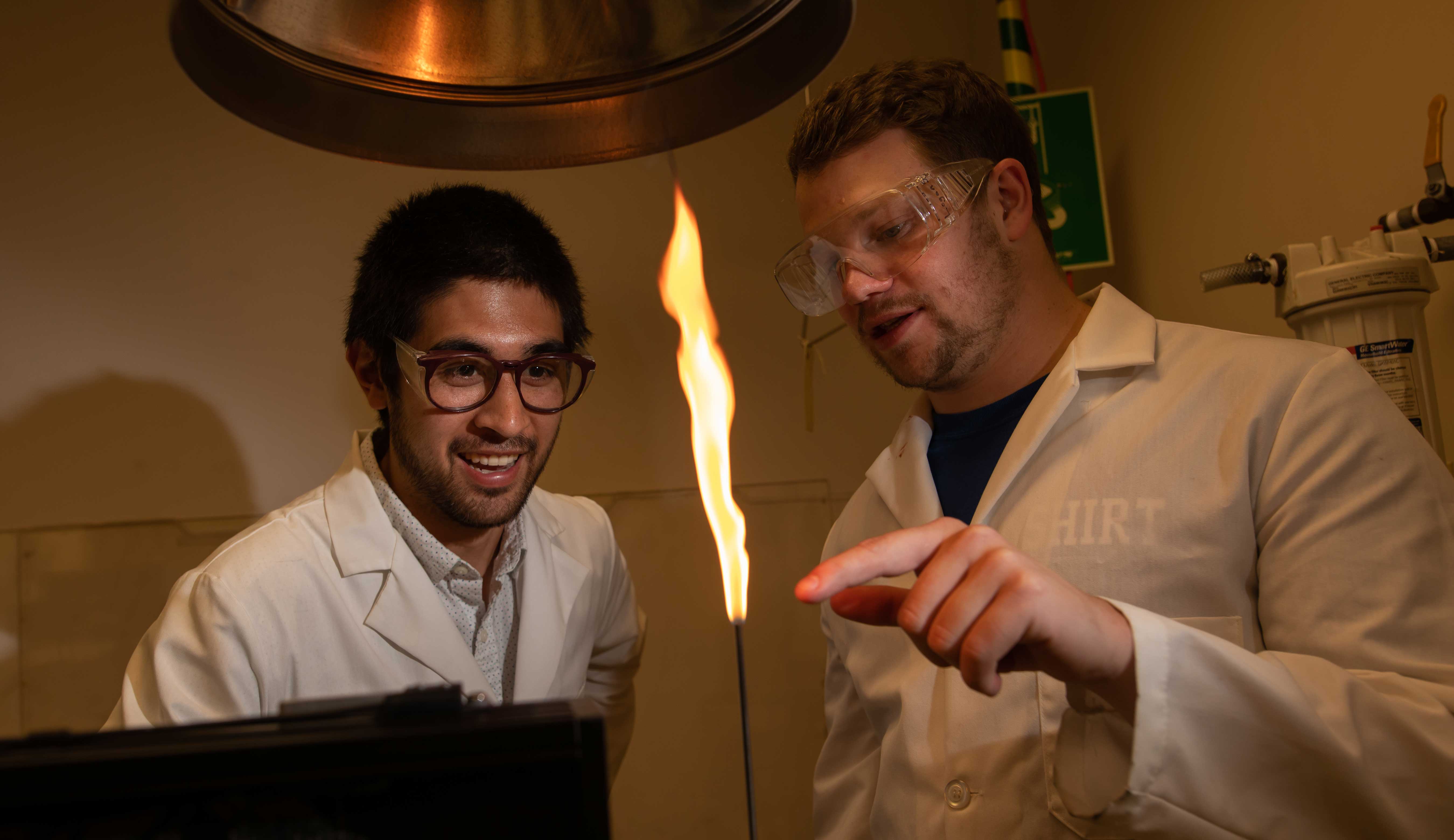 Flame Students in safety gear conduct experiment with small flame