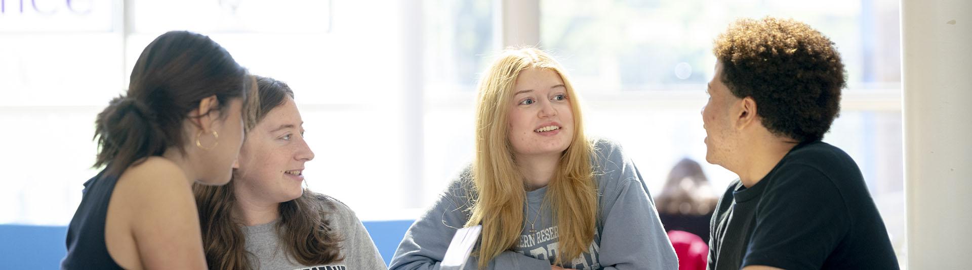 Four students sitting together a table