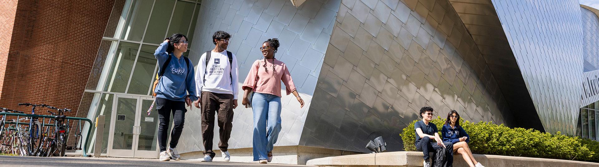 four people standing in front of the Peter B Lewis building