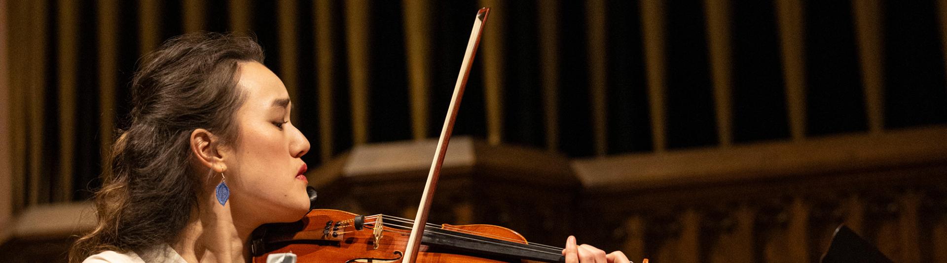 Student performing on a string instrument.