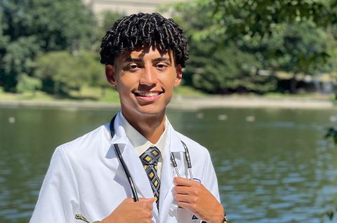 A portrait of Eduardo in front of a lagoon 