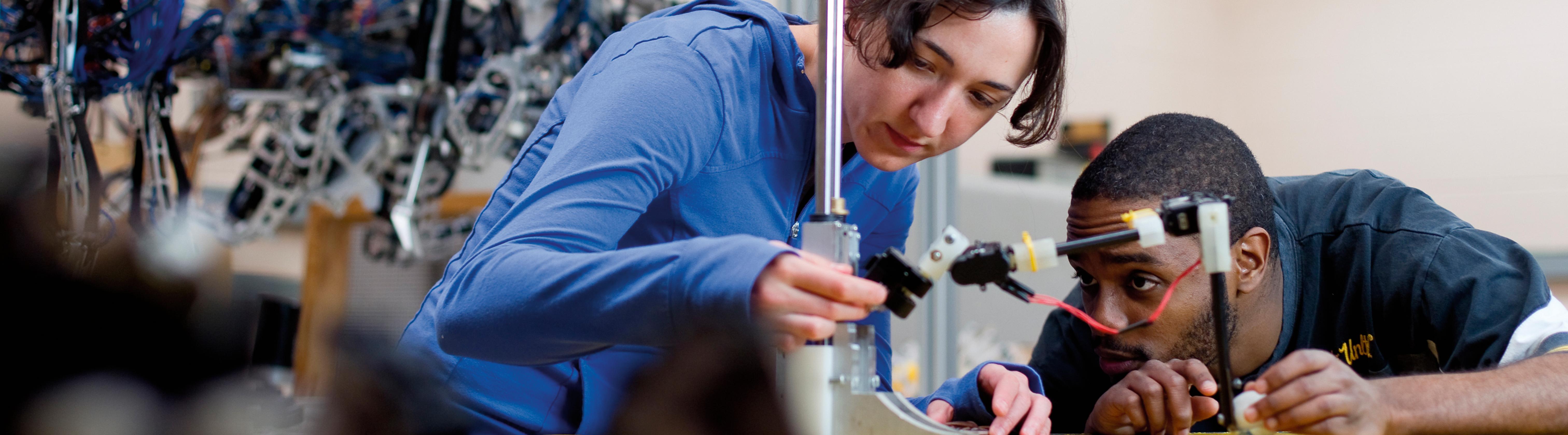 1 white female and one black male student working together in the robotics lab