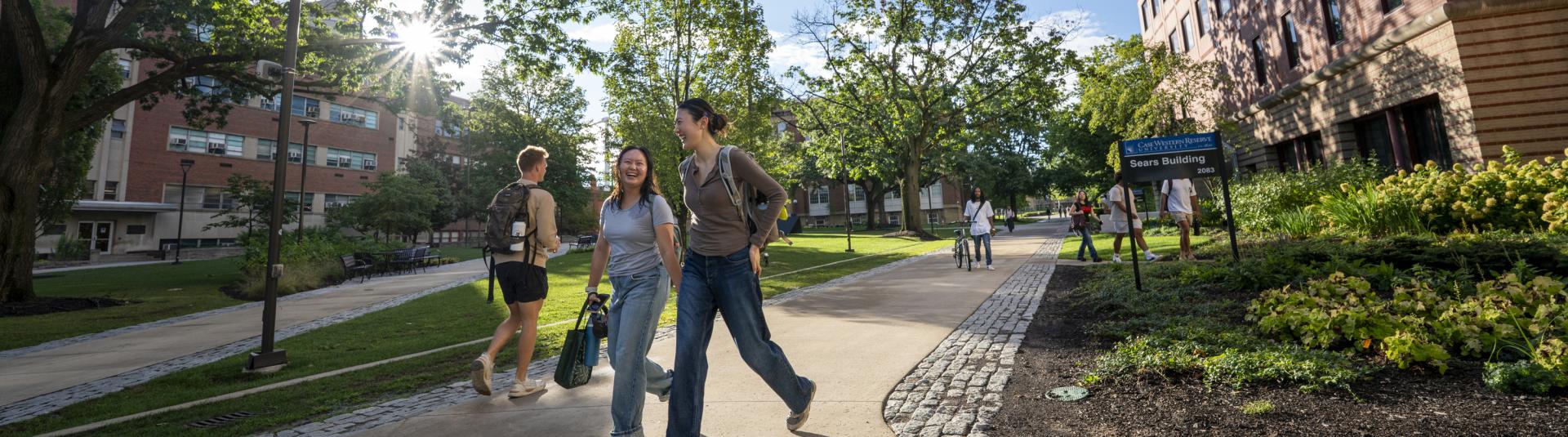 Three people walking on a pathway outside