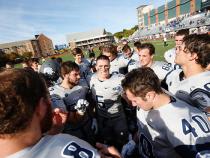 CWRU football team in a huddle at the beginning of a game