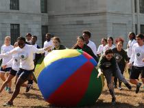Students chasing a huge ball around outside the Tink
