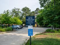 The sign of a parking lot and the parking lot behind it