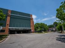 A photo of the outside of a parking garage and the road and houses behind it