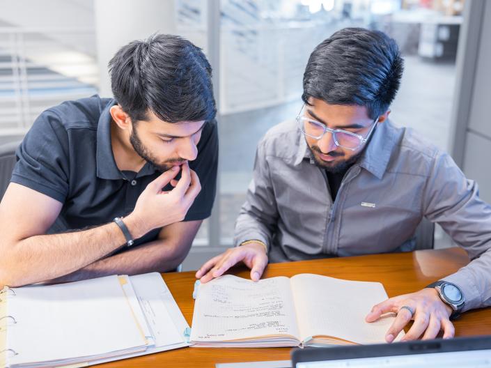 Two students study together in the library.