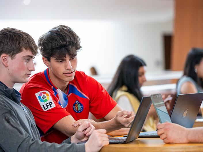 Two people sitting at a desk looking at eachother