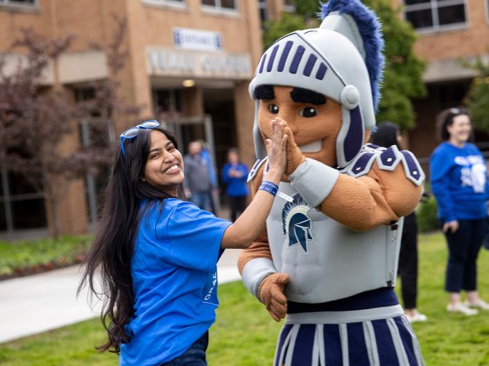 A student high-fives Spartie.