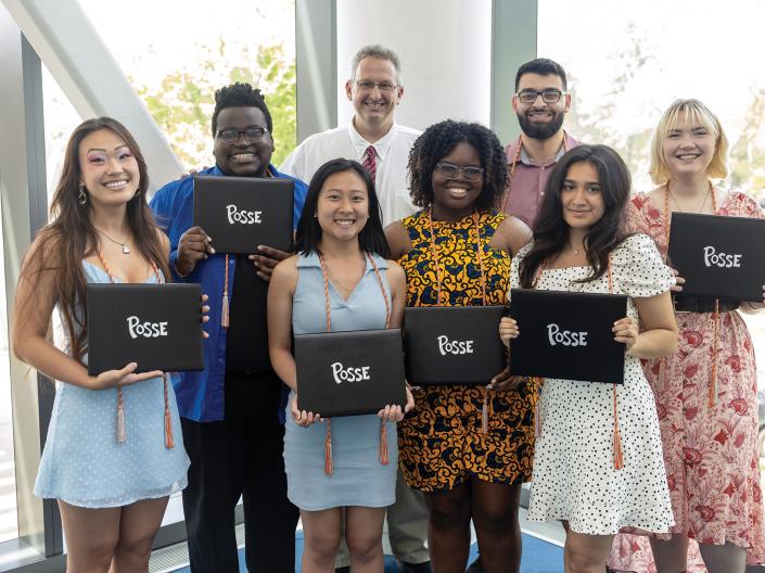 Posse Scholars pose together with signs reading 'Posse' ahead of graduation.