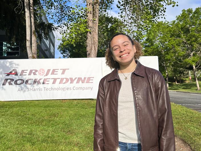 Andrea Silva stands in front of the Aeroject Rocketdyne sign.