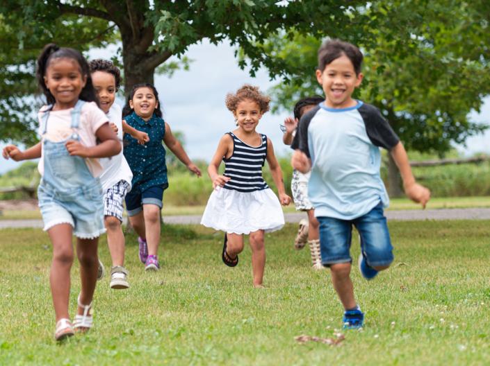 Children running across grass towards the camera.