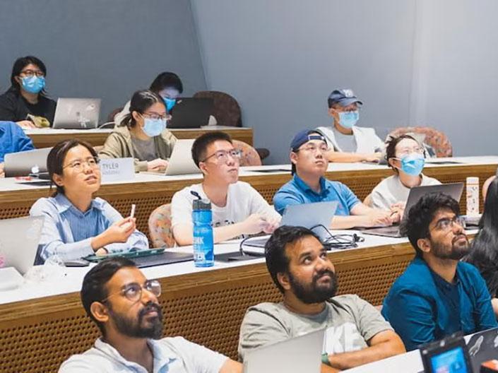 people in rows looking up in a classroom