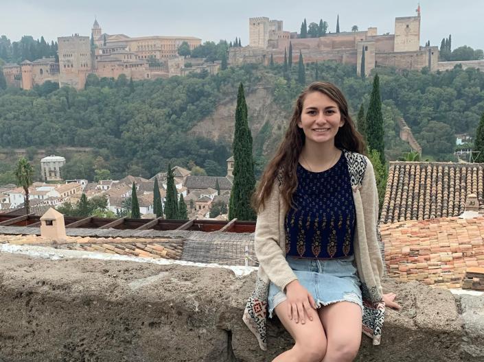 A law student smiles as she poses for a photo while studying abroad.