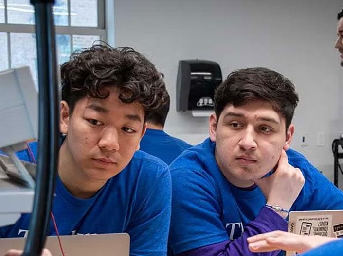 Two people in tshirts looking at an experiment