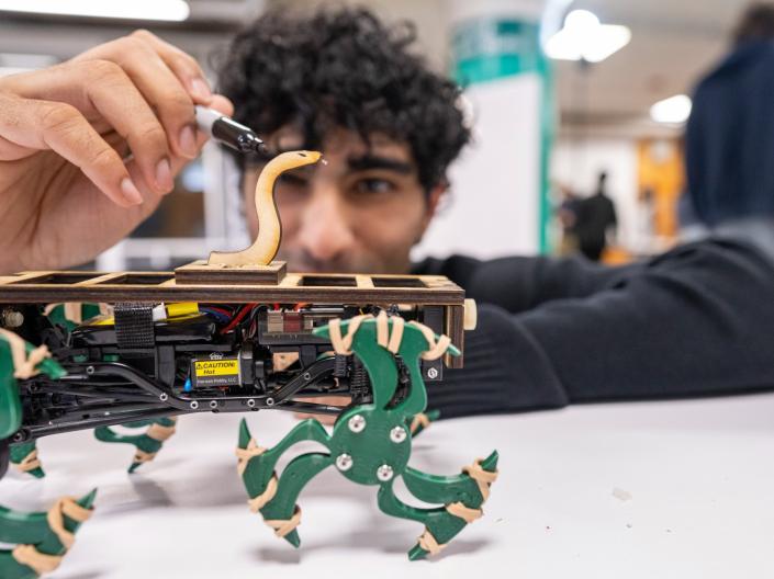 A student works on his whegs machine during the Whegs Competition at Think[box].