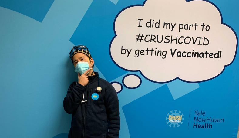 CWRU Jack Cheng poses in front of a sign signifying he received his COVID vaccine