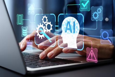 A graphic of AI and gears transparently floating above someone typing on a laptop.