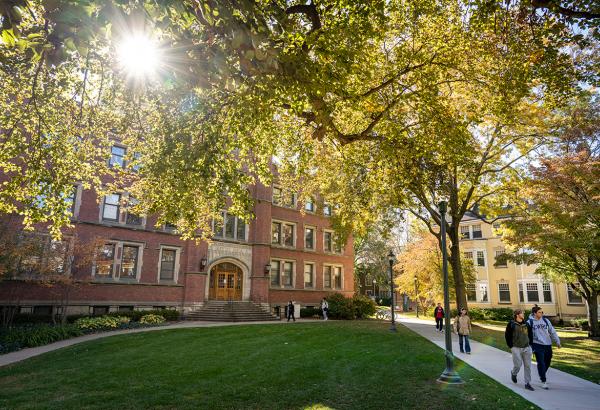 An image of a campus building with students walking by.