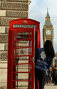 image of girl in telephone booth looking at Big Ben in London, England