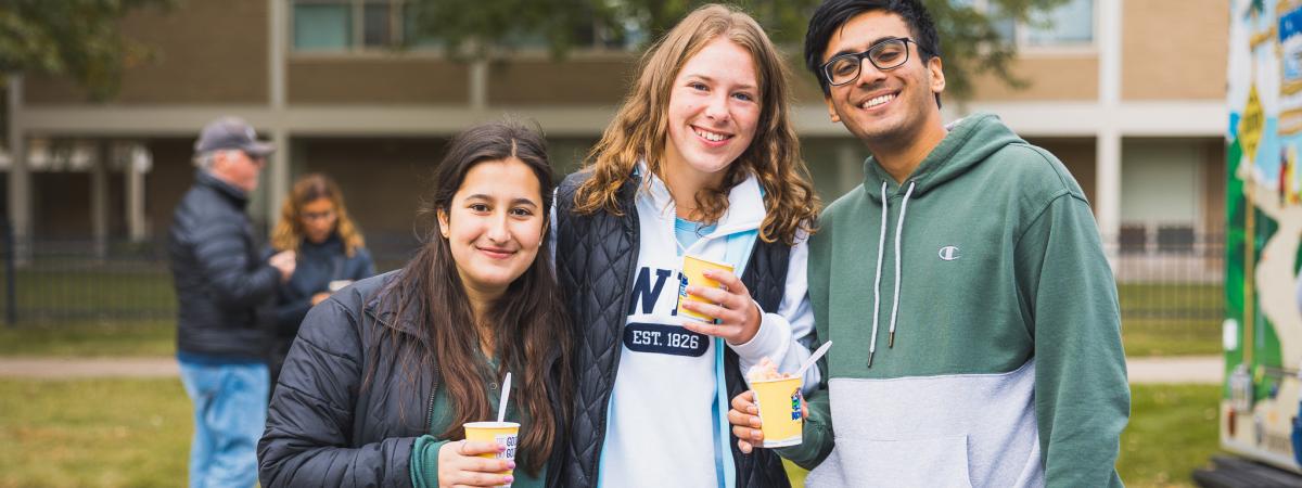 Three students smile at the camera during Homecoming 2022 celebrations