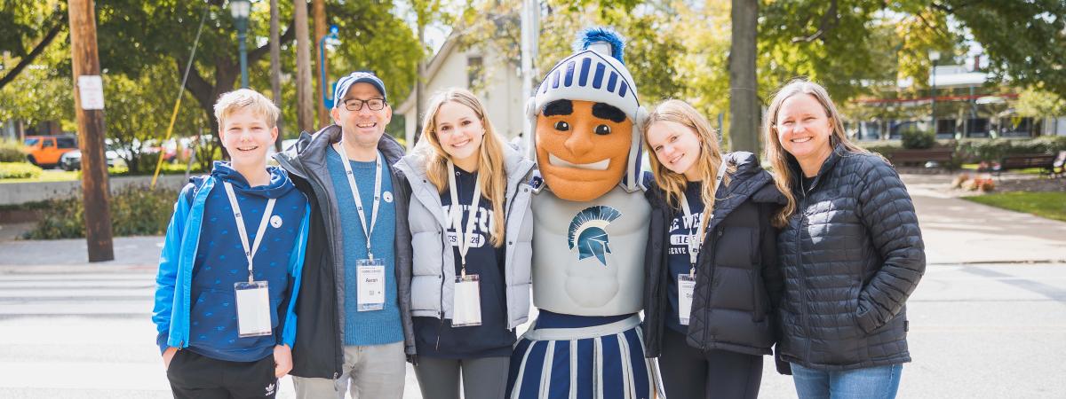 A family of five poses with Spartie at CWRU Homecoming 2022
