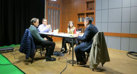 Photo of Brad Crews, seated at a table in a studio recording the podcast with three guests