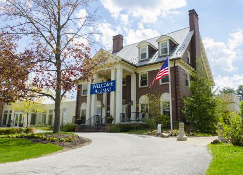 Photo of the Linsalata Alumni Center with a "Welcome Alumni" banner on a sunny day