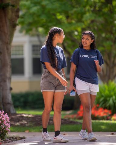 Two students walk through the Mather Quad in the spring