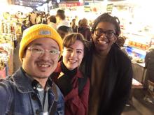 Photo of three people, posed and smiling for the camera