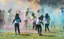 Photo of people running through a cloud of colors during the Holi Festival of Colors at CWRU