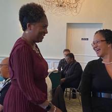 Two women are talking to each other, laughing