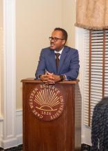 Dexter Voisin stands at a podium, speaking to a group at the AAAA welcome reception, homecoming 2022