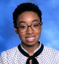 LaNyah Terry smiles for a school photo wearing a white and black polka dot blouse and glasses