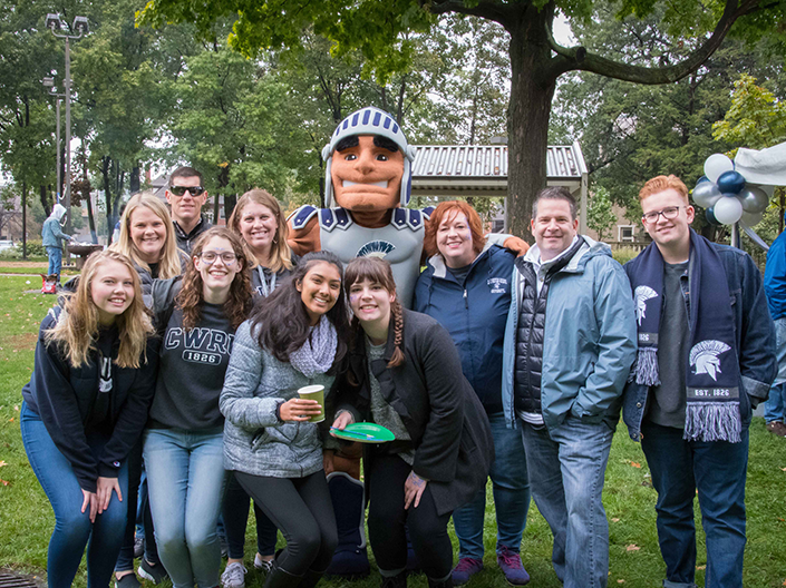 Photo of alumni, students and families with Spartie posed and smiling for the camera at Homecoming