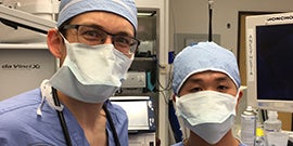 Photo of two people in scrubs wearing face masks in an operating room