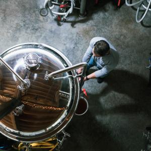 Brewer stands by beer brewing equipment