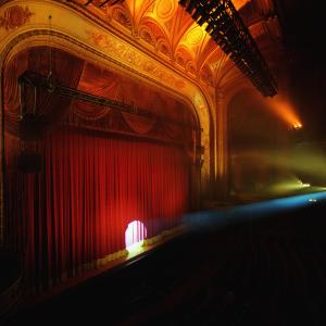 Closed theater curtain with spotlight showing at front