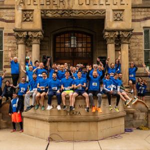 Hudson Relays alumni team poses in team T shirts in front of Adelbert Hall