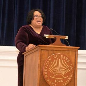 Linda Sharpe-Taylor speaks at a podium at an event while wearing formal attire