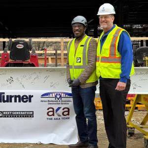 ISEB crew members smile at camera at topping out ceremony