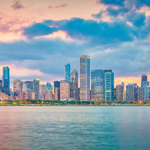 Chicago skyline near the water with red-tinted sky above and reflected in the water