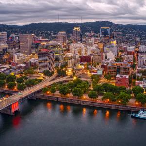 Portland, Oregon, skyline against cloudy sky, behind water