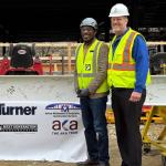 ISEB crew members smile at camera at topping out ceremony