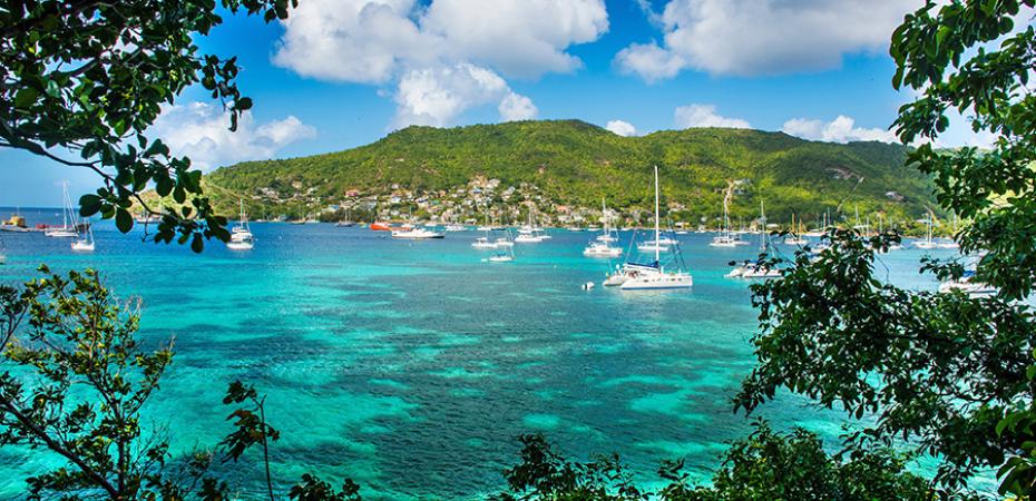 A Caribbean port shown in the daytime, with a sunny sky with some clouds